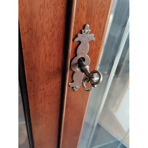 105 - A vintage wooden display cabinet with lighting and glass shelves. Includes keys.