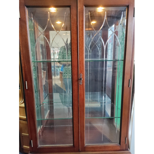 105 - A vintage wooden display cabinet with lighting and glass shelves. Includes keys.