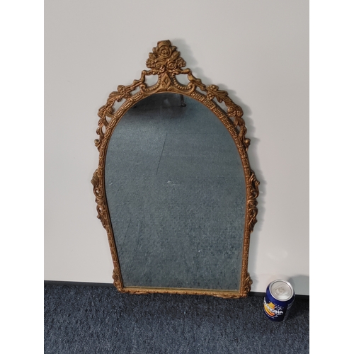 109 - A vintage ornate gold gilt frame wall mirror. H 68cm x 35cm.