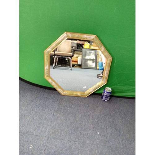 112 - An octagonal floral framed mirror. Measures 21in x 21in.