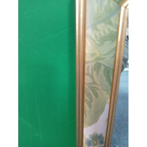 112 - An octagonal floral framed mirror. Measures 21in x 21in.