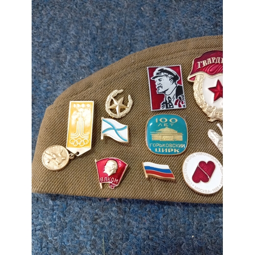 92 - A soviet military hat, possibly a budenovka or pilotka with various soviet era pins and badges.