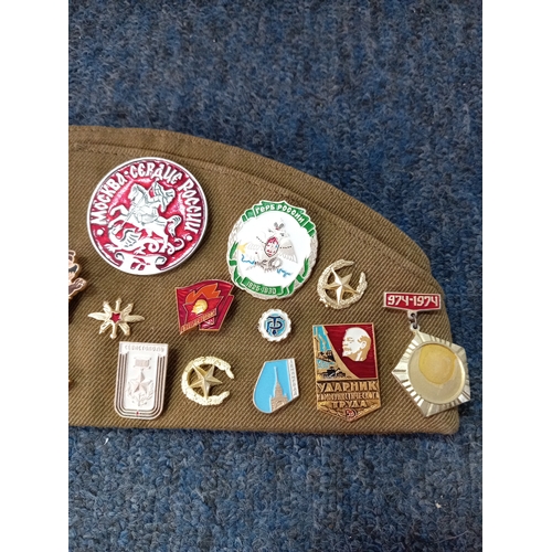 92 - A soviet military hat, possibly a budenovka or pilotka with various soviet era pins and badges.