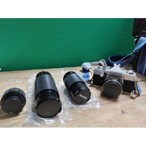 30 - A praktica mtl3 camera with spare lenses, clicker, flash attachment and storage bag