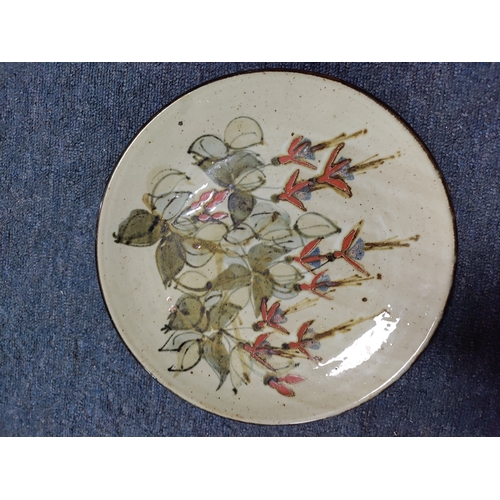 215 - A vintage Colin Kellam studio pottery wall plate decorated with a floral pattern. Diameter 28cm.
