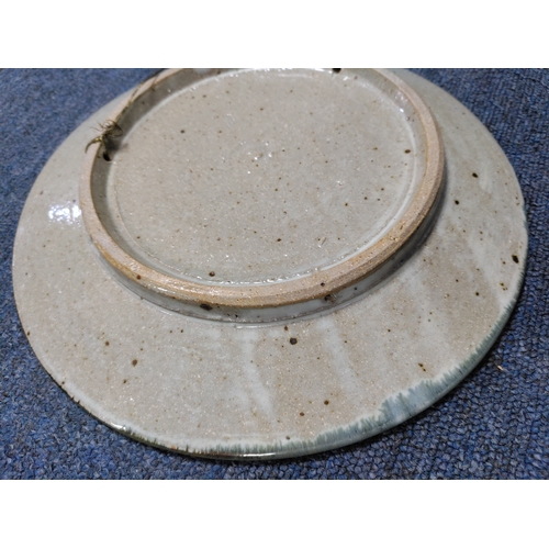 215 - A vintage Colin Kellam studio pottery wall plate decorated with a floral pattern. Diameter 28cm.