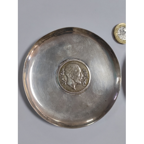272 - A pair of ashtrays with coins mounted in the centre. One has a silver 1932 Iraq 200 fils and is beli... 