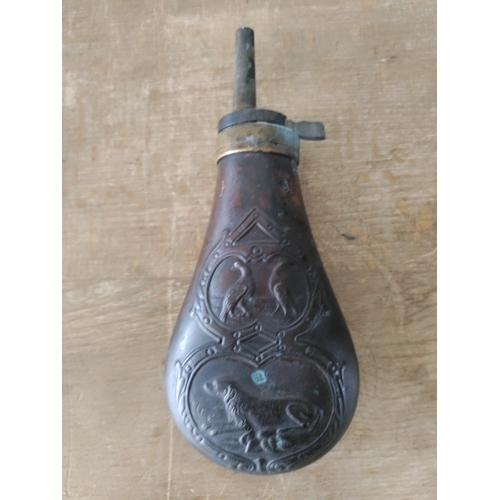 268 - A brass embossed gunpowder flask depicting 2 birds and a running dog