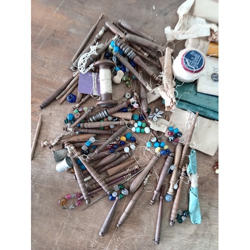89 - A collection of vintage sewing bobbins, thread and thimbles to include a hallmarked silver thimble.