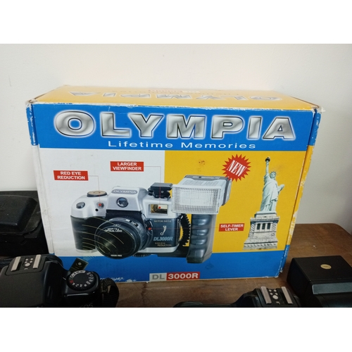57 - A collection of cameras and equipment to include an olympia DL3000R new in the box, Two Canon EOS 10... 