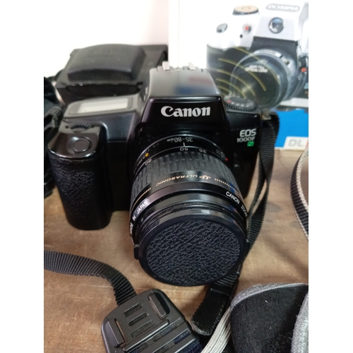 57 - A collection of cameras and equipment to include an olympia DL3000R new in the box, Two Canon EOS 10... 
