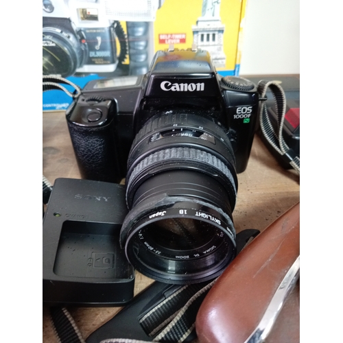 57 - A collection of cameras and equipment to include an olympia DL3000R new in the box, Two Canon EOS 10... 