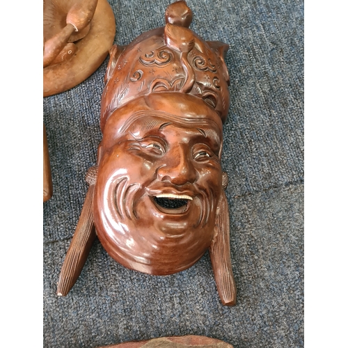 12 - A job lot of mainly wooden ethnic items to include: a carved statue; a carved mask; a carved tray; a... 