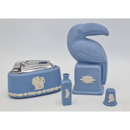 247 - A collection of 4 pieces of Wedgwood Jasperware in Blue. Includes a table lighter; a thimble; a mini... 