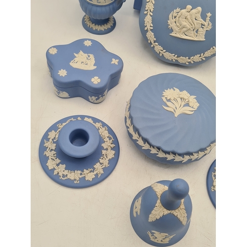 244 - A collection of 9 pieces of Wedgwood Jasperware in Blue. Includes 2 vases; 2 candlesticks; a bell an... 