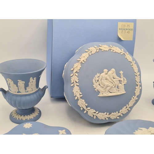 244 - A collection of 9 pieces of Wedgwood Jasperware in Blue. Includes 2 vases; 2 candlesticks; a bell an... 