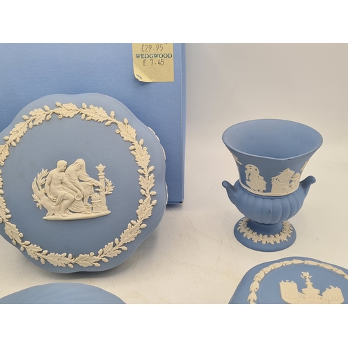 244 - A collection of 9 pieces of Wedgwood Jasperware in Blue. Includes 2 vases; 2 candlesticks; a bell an... 