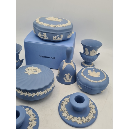 244 - A collection of 9 pieces of Wedgwood Jasperware in Blue. Includes 2 vases; 2 candlesticks; a bell an... 