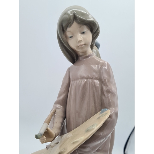 190 - Lladro Nao Porcelain Girl Artist Painter Figurine with palette. Measures 14cm high by 18cm wide.