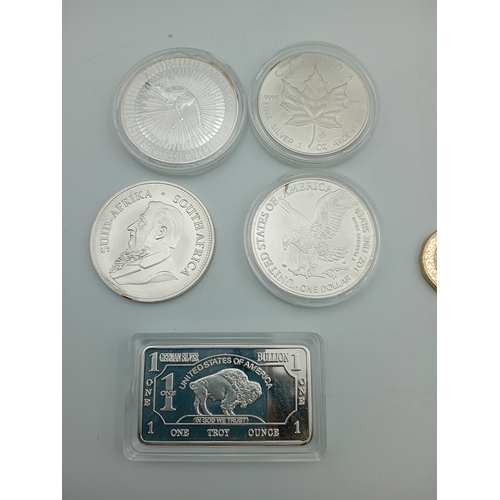 A collection of reproduction silver coins and a bar. Please note these ...