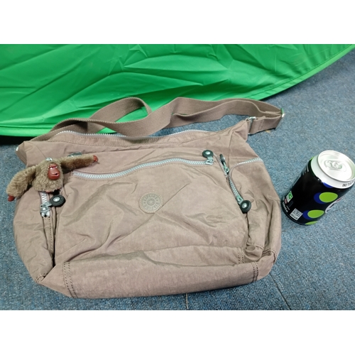 269 - A Brown Kipling crossbody handbag with monkey charm.