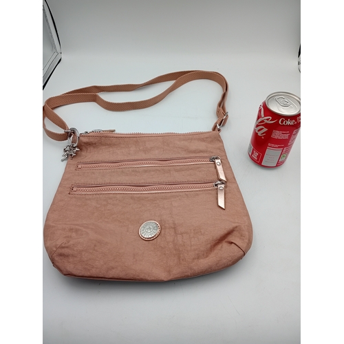 281 - A Kipling crossbody handbag in a champagne colour.