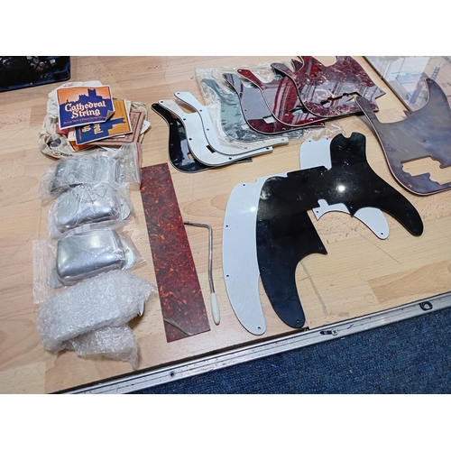 143 - A collection of vintage guitar stratch plates, strings, precision bass bridge, pickup covers and mor... 