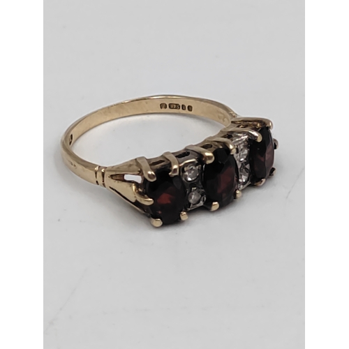 392 - A hallmarked 375 9ct gold ring set with garnets and diamonds. Size N.