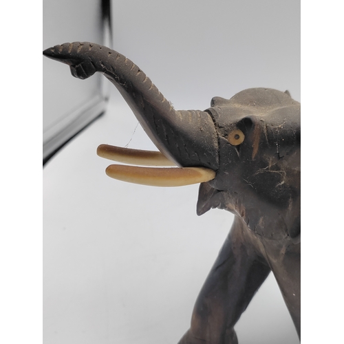 31 - A trio of carved ebony and bone elephant figurines. Some damage as shown in pictures.