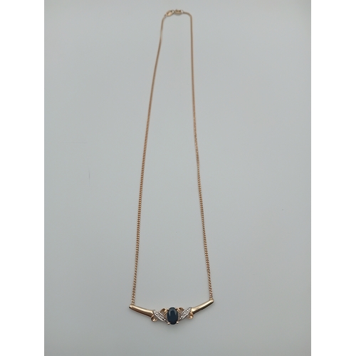 385 - A stamped 375 9ct gold pendant necklace set with a sapphire and diamonds. Length 17.5 inches.