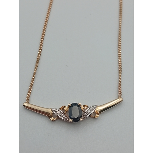 385 - A stamped 375 9ct gold pendant necklace set with a sapphire and diamonds. Length 17.5 inches.