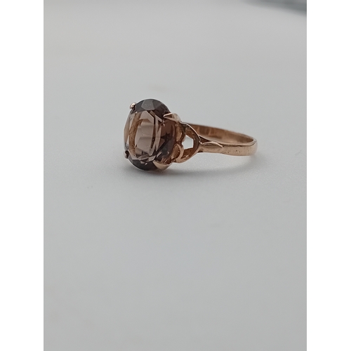 389 - A tested 9ct gold ring set with smokey Quartz. Size T