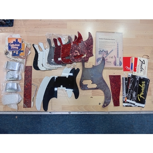 143 - A collection of vintage guitar stratch plates, strings, precision bass bridge, pickup covers and mor... 