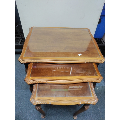 129 - A nest of tables with glass tops. Largest measurements are 55cm x 54cm x 42cm.