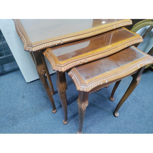 129 - A nest of tables with glass tops. Largest measurements are 55cm x 54cm x 42cm.