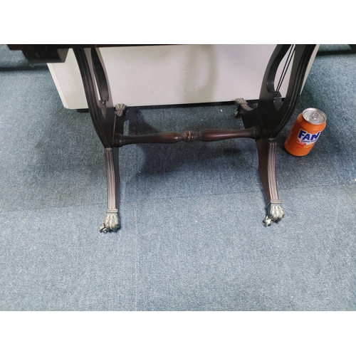 137 - A mahogany drop-leaf table with claw feet on castors.
