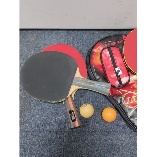 162 - A collection of table tennis paddles, two balls and a Dunlop paddle case.