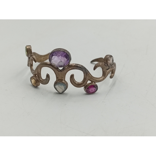 369 - A vintage stamped 925 silver bangle set with colourful stones and a hallmarked silver pendant with a... 