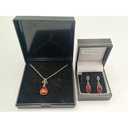 385 - An amber jewellery set, to include a necklace with an amber celtic pendant and a pair of amber earri... 
