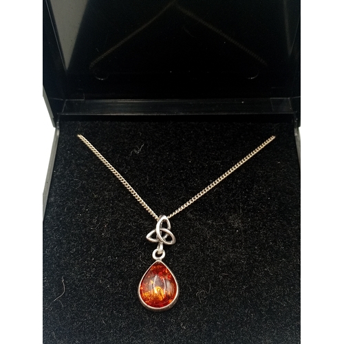 385 - An amber jewellery set, to include a necklace with an amber celtic pendant and a pair of amber earri... 