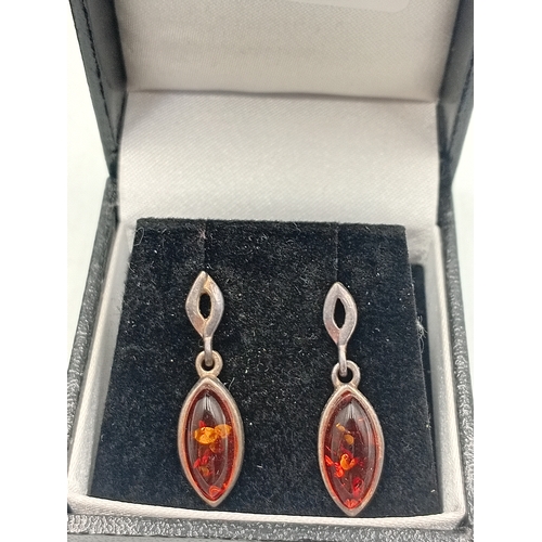 385 - An amber jewellery set, to include a necklace with an amber celtic pendant and a pair of amber earri... 