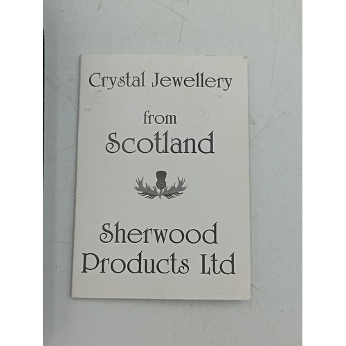388 - A sherwood crystal jewellery thistle pendant on a silver necklace with box and paper and a stamped 9... 