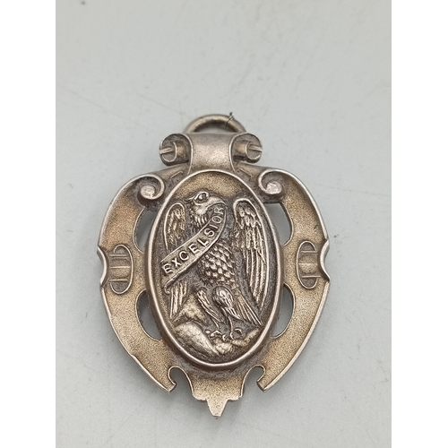 392 - A stamped 925 silver celtic style brooch and a stamped silver HND Excelsiot badge / pendant