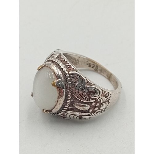 395 - A hallmarked 925 silver ring set with an orange stone and two costume rings.