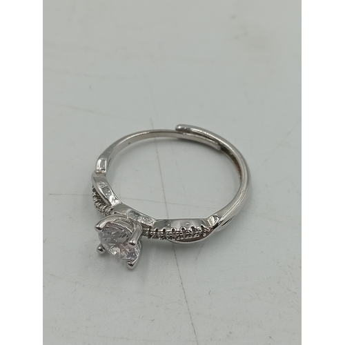 395 - A hallmarked 925 silver ring set with an orange stone and two costume rings.