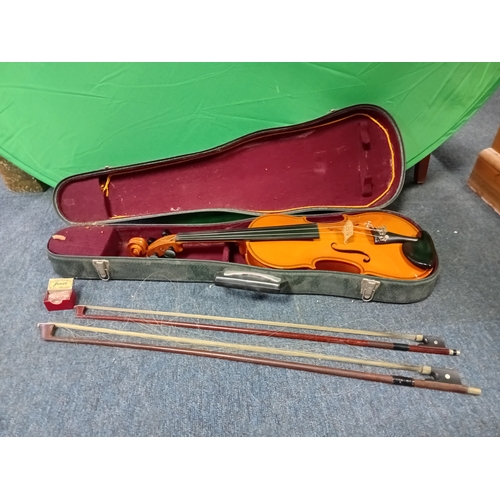 121 - A vintage violin in a case with 2 bows and violin resin.