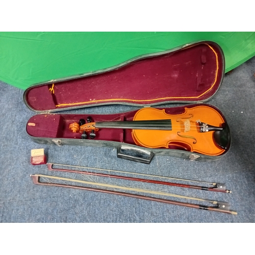 121 - A vintage violin in a case with 2 bows and violin resin.