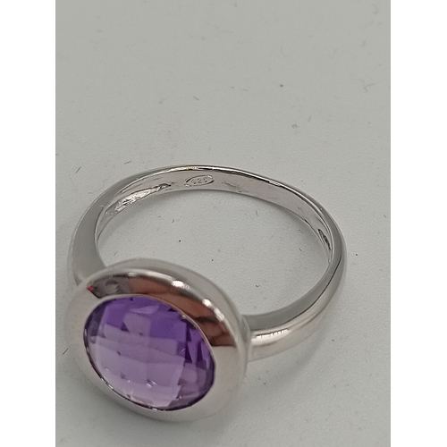 396 - A stamped 925 silver ring set with a purple stone. Size P.