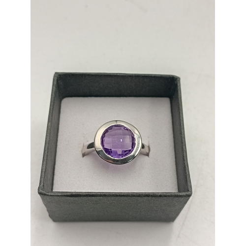 396 - A stamped 925 silver ring set with a purple stone. Size P.