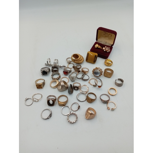 314 - A good quantity of costume rings including a Catier Love style ring, signet rings, etc